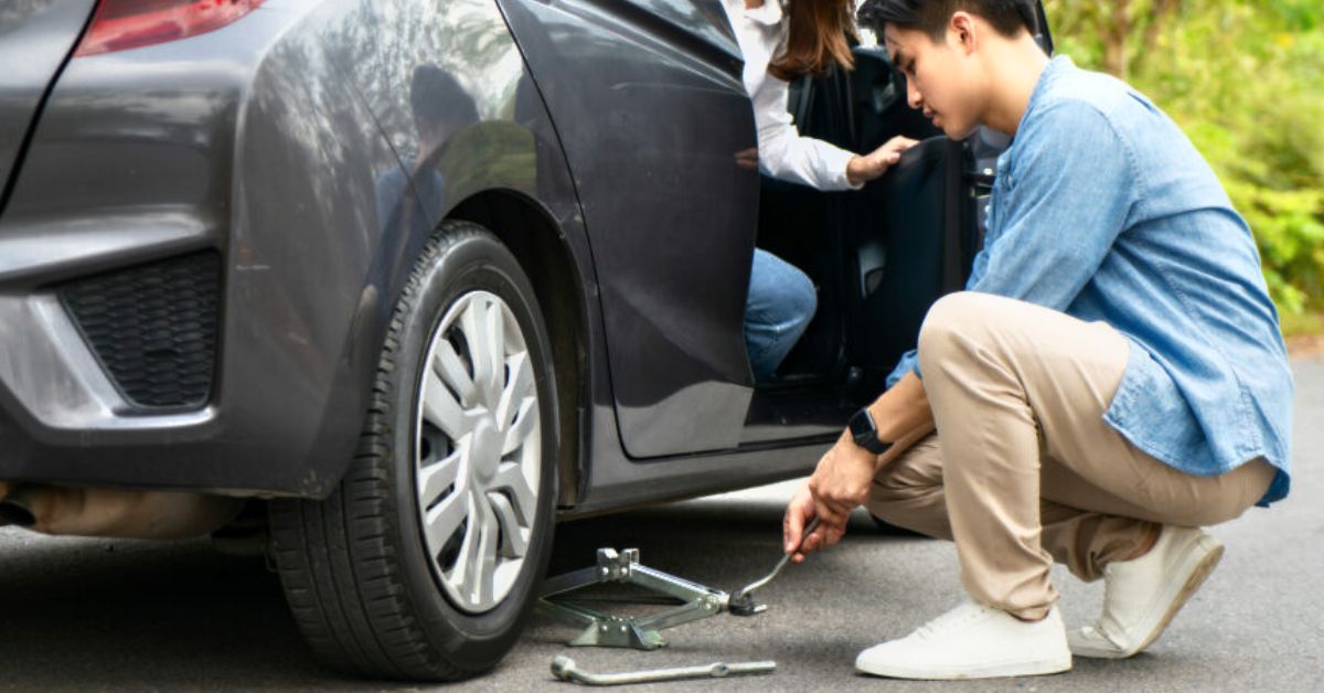 a person changing wheels due to car breakdown